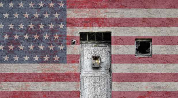 Door and broken window superimposed on American flag